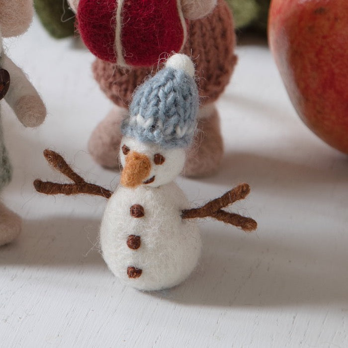 Blau bemützter Filz-Schneemann Schneefreunde zwischen Weihnachtsdekoration – Herstelleraufnahme.