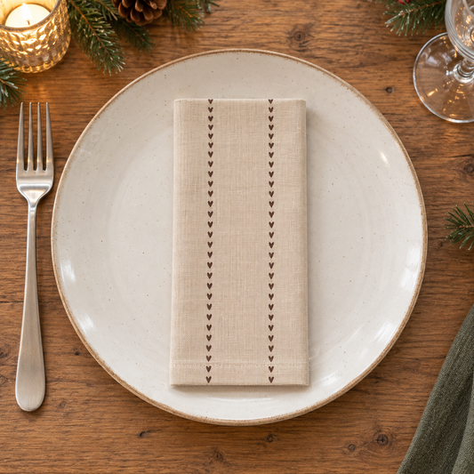 Klein rechteckig gefaltete Serviette Valentina auf einem Essteller an einer weihnachtlichen Tafel
