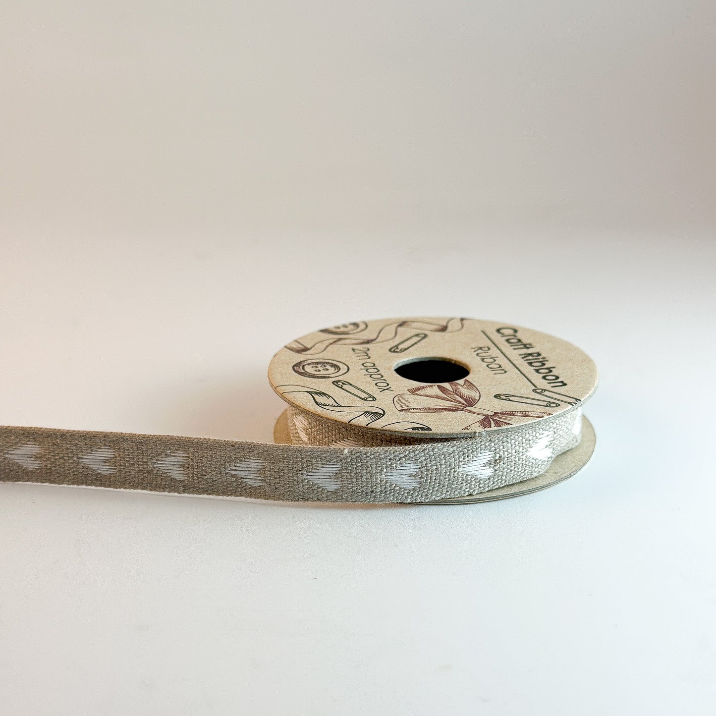 Vintage Hearts linen ribbon by Wohnen auf dem Land in red, 15mm wide, displayed on a roll with various patterns.