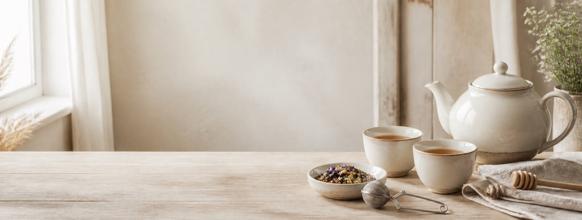 Gemütliche Teeszene mit Teekanne, Tassen, Kräutertee und Honig
