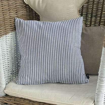 Blaues Kissen "Lina" mit maritimen Streifen, 45x45cm, von Wohnen auf dem Land, liegt auf einem Sofa.