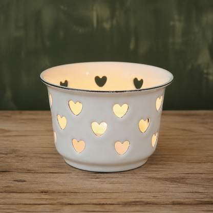 Teelichthalter Candle Kiss Weiß aus Emaille mit Herzen vor grünem Hintergrund