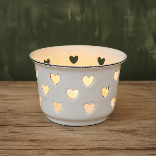 Teelichthalter Candle Kiss Weiß aus Emaille mit Herzen vor grünem Hintergrund