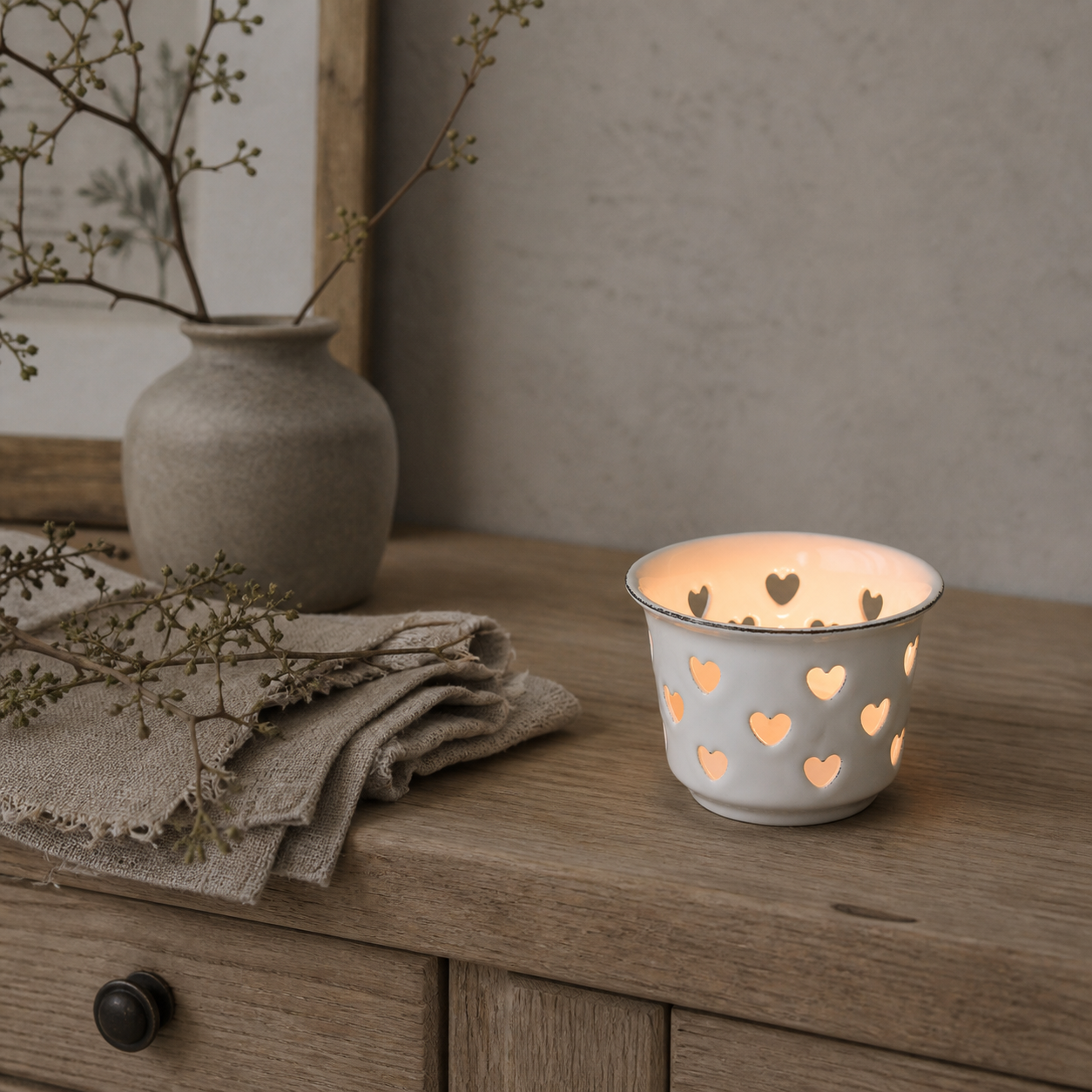 Teelichthalter Candle Kiss Weiß auf einer hellen Holzkommode