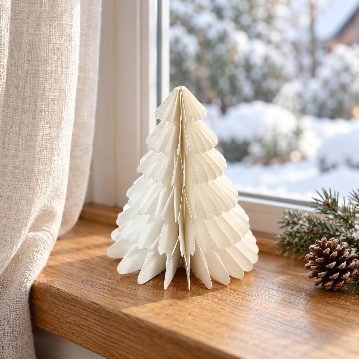 Kleiner weißer Papierbaum auf einer winterlichen Fensterbank