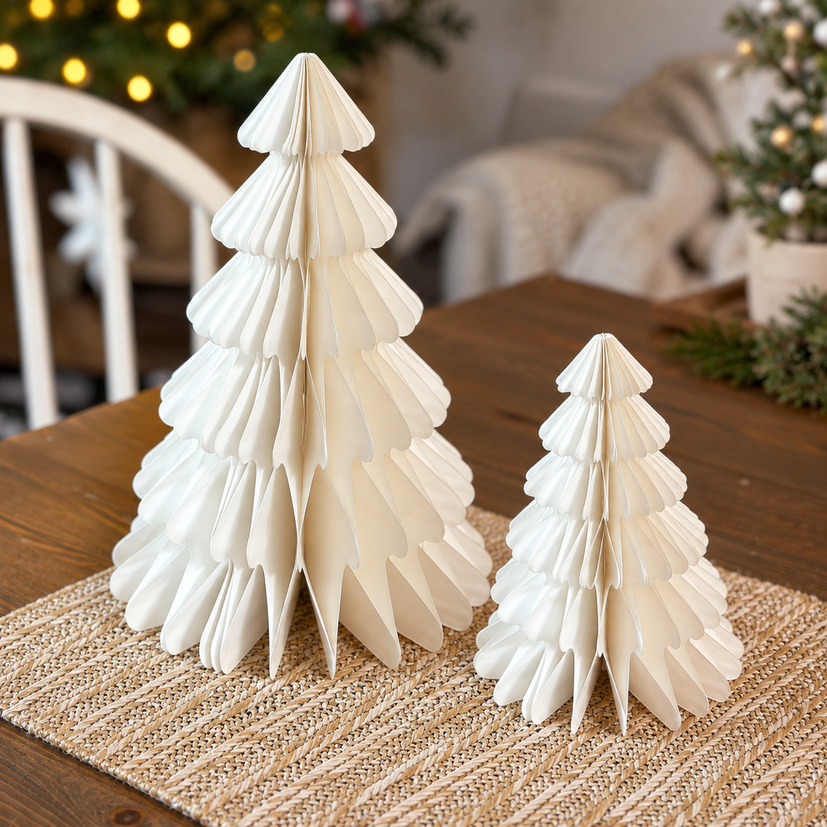 Weiße Papierbäume in 15 und 25 cm Höhe gemeinsam auf einem gedeckten Holztisch