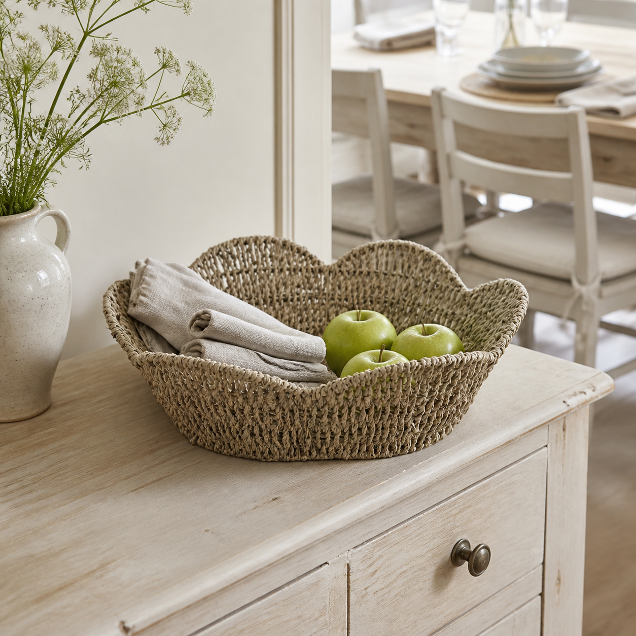Seegras-Korbschale Delice mit Leinen und Äpfeln auf einem Sideboard