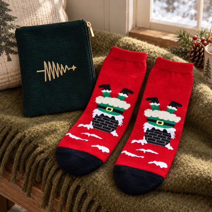 Geschenkset „Tannenfreude“ Reißverschlusstasche und Socken Grün/Rot 36–40 auf einer olivfarbenen Decke im weihnachtlichen Schlafzimmer