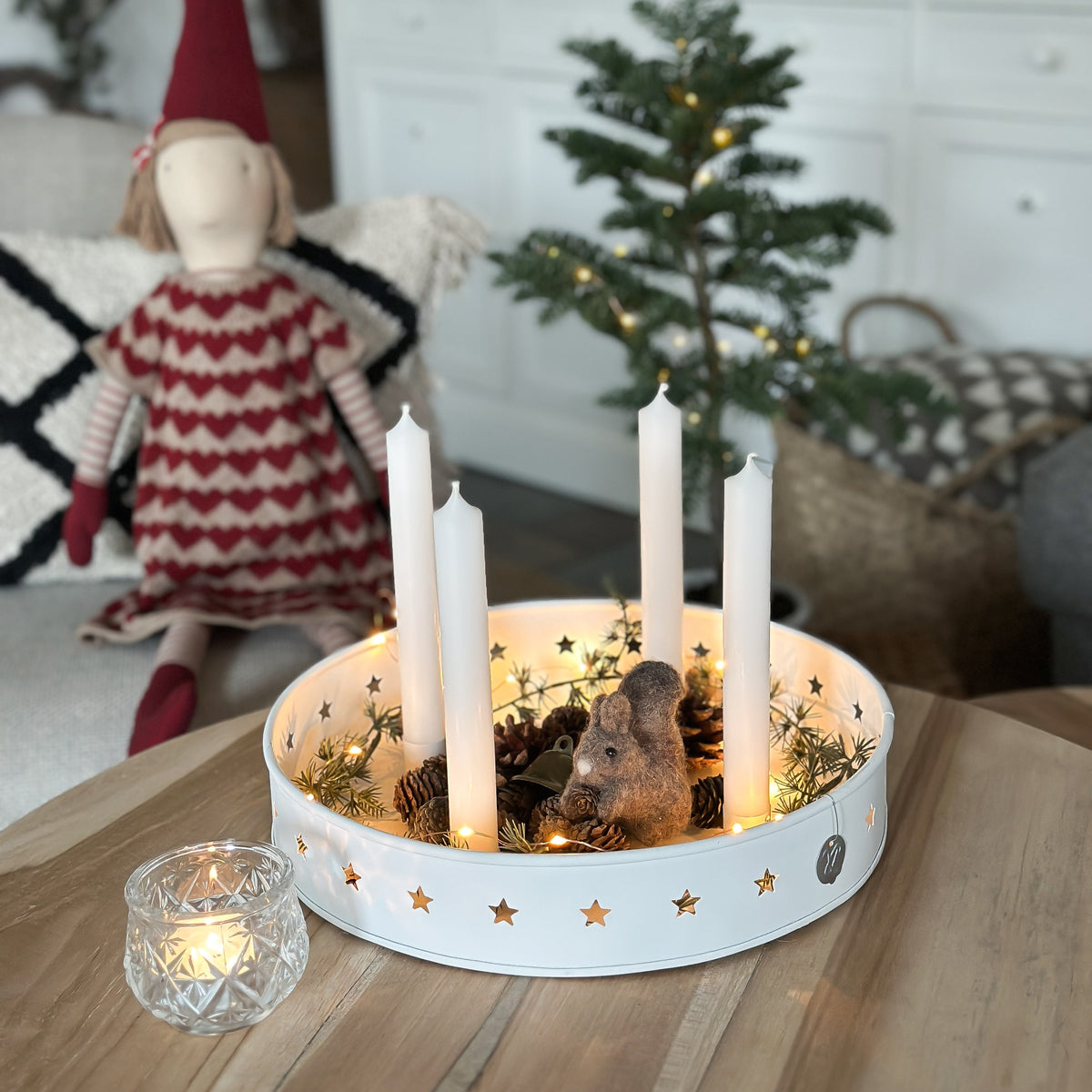 Kerzenschale Sterne mit Lichterkette und winterlicher Dekoration auf einem Holztisch.