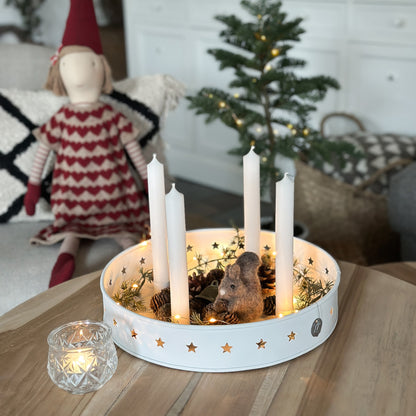 Kerzenschale Sterne mit Lichterkette und winterlicher Dekoration auf einem Holztisch.