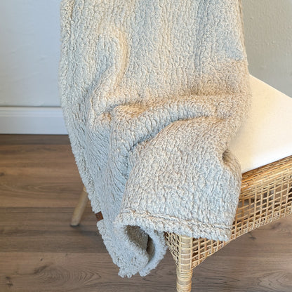 Taupefarbene Teddy Wohndecke auf einem Stuhl
