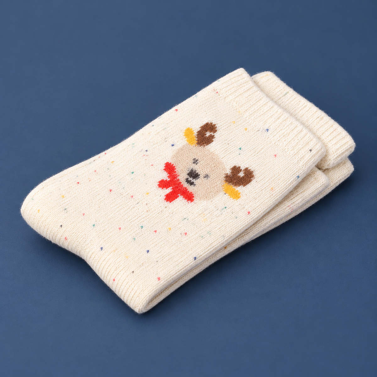 Dicke Rentiersocken „Winterfreund“ Creme 36–41 aus schräger Perspektive vor ruhigem Studiohintergrund