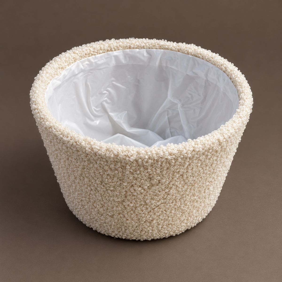 Teddy-Übertopf in Creme von schräg oben mit sichtbarem Folieneinsatz.