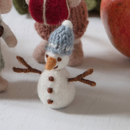 Blau bemützter Filz-Schneemann Schneefreunde zwischen Weihnachtsdekoration – Herstelleraufnahme.