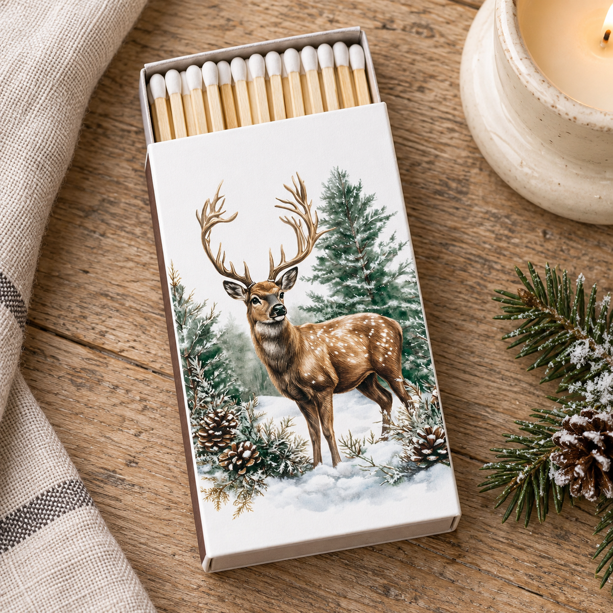 Streichhölzer Winter Stag neben einem cremefarbenen Kerzenhalter auf einem Holztisch