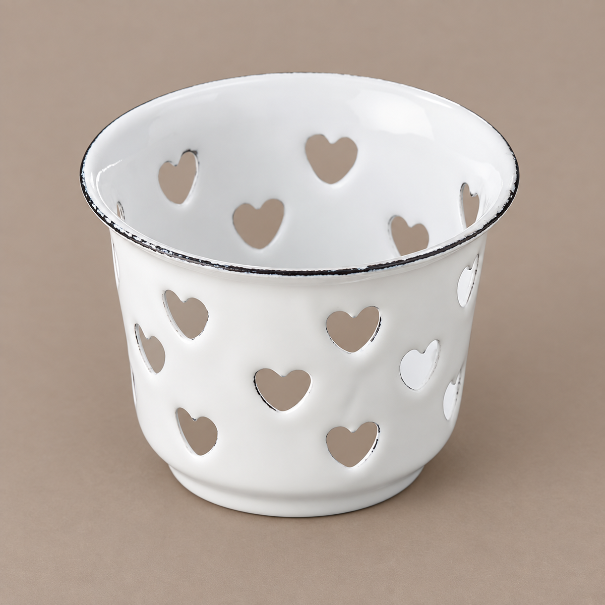 Weißer Emaille-Teelichthalter Candle Kiss mit Herzausschnitten aus leicht erhöhter Perspektive freigestellt