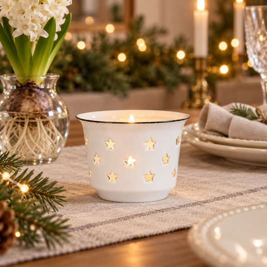 Weißer Emaille-Teelichthalter Nordic Star mit Sternausschnitten auf einer festlich gedeckten Weihnachtstafel