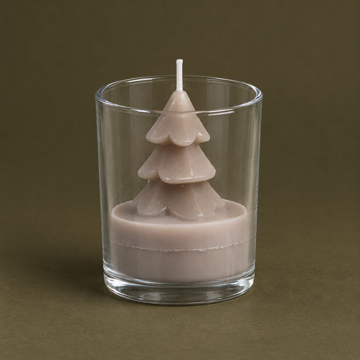 Taupefarbene Tree Candle in Tannenform im klaren Glas auf olivfarbenem Untergrund