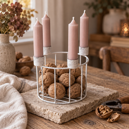 Vintageweißer Kerzenkorb mit ganzen Walnüssen und vier unangezündeten roséfarbenen Stabkerzen