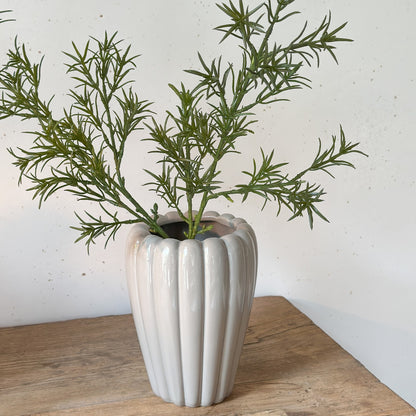 Künstlicher Asparagus-Zweig in Vase dekoriert